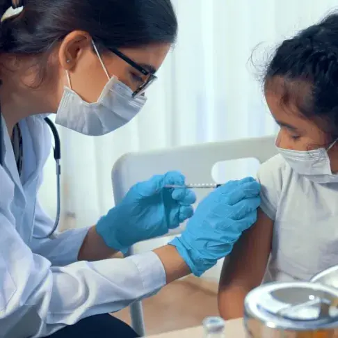 Nurse administering a vaccine injection to a child.