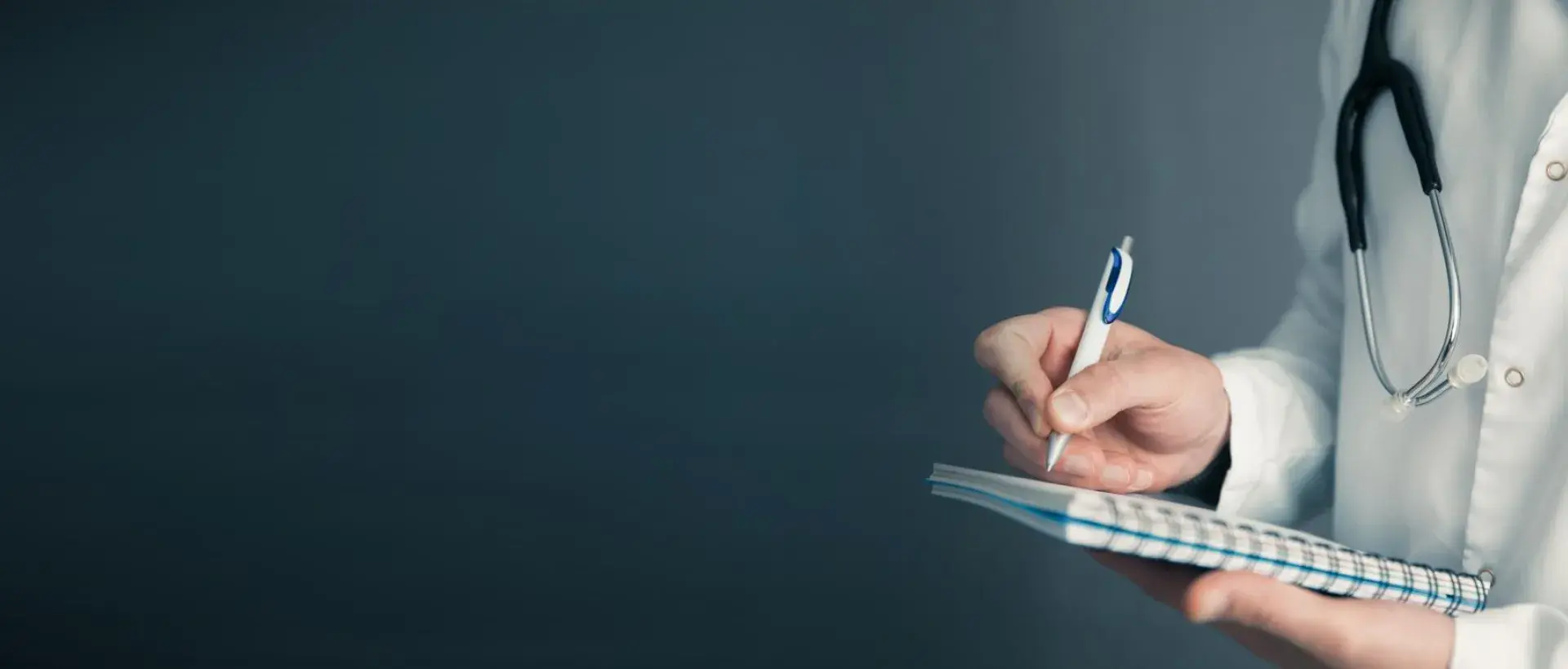 A physician writing notes on a notepad